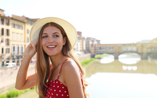 Portrait of young woman with hat and dress visiting Tuscany in Italy