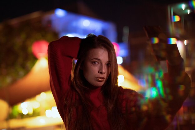 Photo portrait of young woman with illuminated lights at night