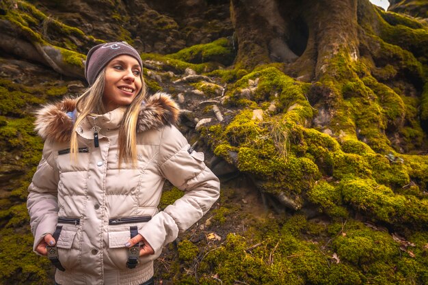 portrait of a young woman with jacket and hat in a forest