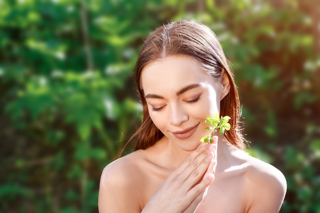 Foto ritratto di una giovane donna con una foglia in mano