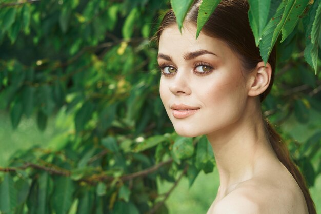 Portrait of young woman with leaves outdoors