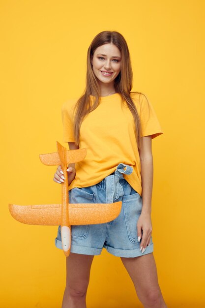 Portrait of a young woman with a model of a yellow plane Lifestyle unaltered