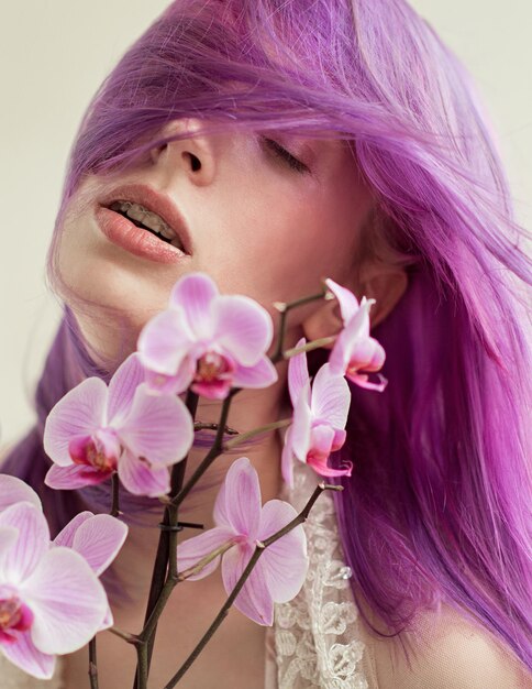 Portrait of a young woman with purple hair and orchids