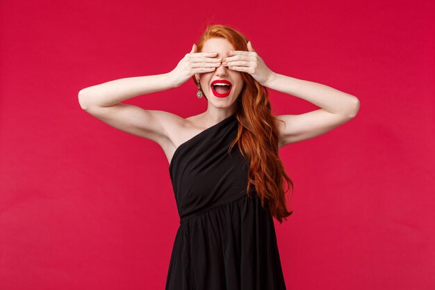 Portrait of a young woman with red hair against pink background