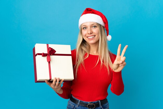 portrait young woman with santa hat holding gift