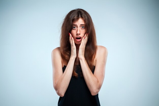 Portrait of young woman with shocked facial expression