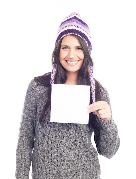 Portrait of young woman with a sweater and Peruvian hat woolen holding sign card