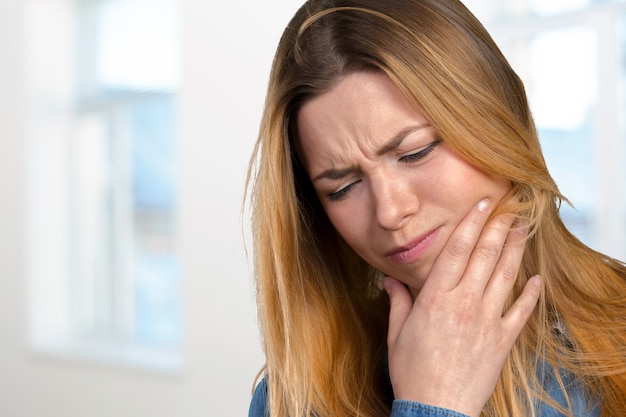 Portrait of young woman with toothache