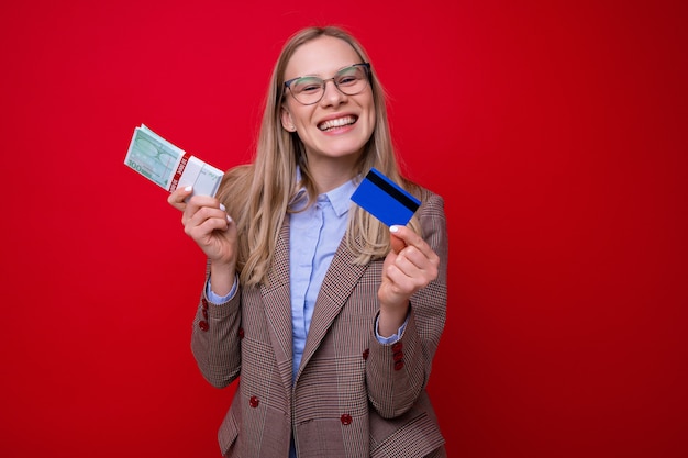 Portrait of a young woman with a wad of money and a credit card