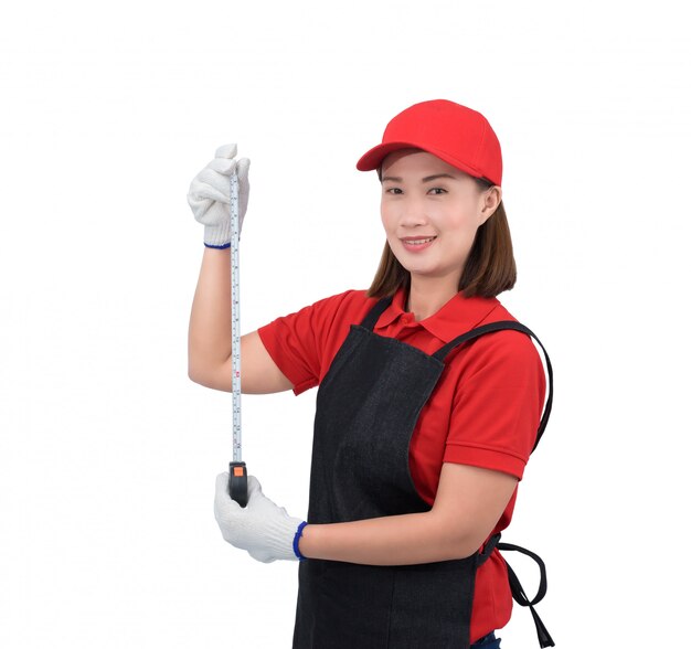 Portrait of young woman worker smiling in red uniform with apron, glove hand holding Measuring Tape isolated on white backround