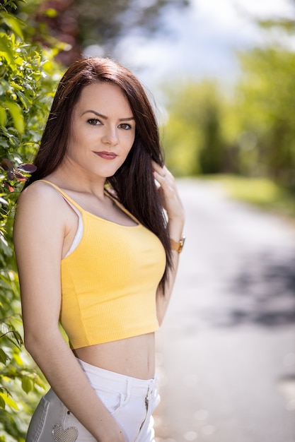 Portrait of a young woman in yellow top and white shorts in summer