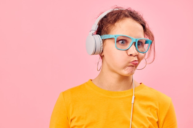 Portrait of a young woman yellow tshirt headphones entertainment music fun isolated backgrounds unaltered