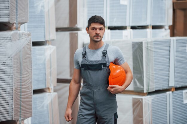 Portrait of young worker in unifrorm that is in warehouse.