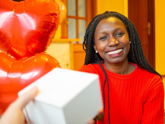 Portrait young of a young woman holding a present with both hands during valentine's day