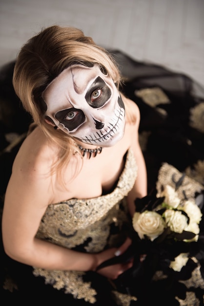 Portrait of zombie woman with painted skull face