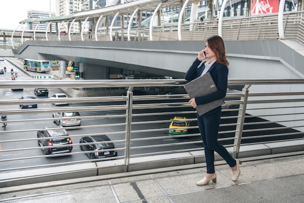 Portraits of beautiful asian woman look confidence is standing and holding cellphone