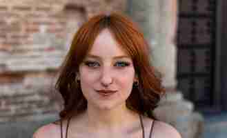 Photo portraits of a charming red-haired girl with a cute face. girl posing for the camera in the city cen