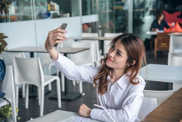 Ritratti di donna asiatica bella bella scattare una foto di selfie in urbano.