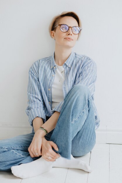 Portraits of a stylish european woman with glasses in a bright room a confident woman is a