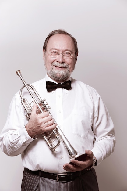 Portraitsmiling adult man musician with a trumpet