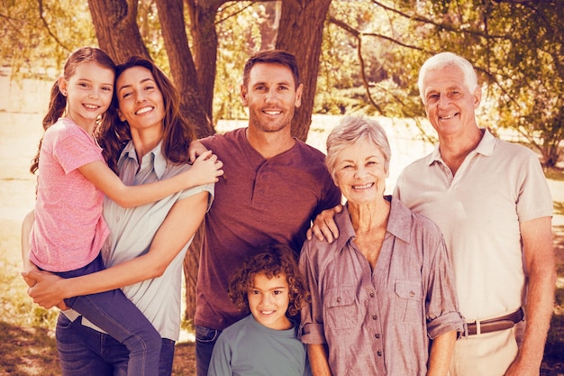 Portrarit of happy family in park by tree