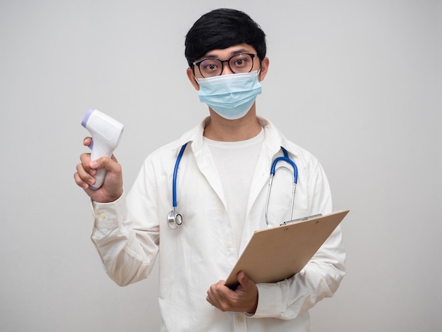 Portret arts die een medisch masker draagt, houdt een infraroodthermometer vast met een kuikenlijstbord