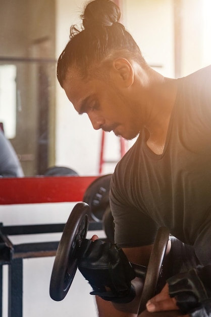 Portret atletische aziatische man die spieren oppompt