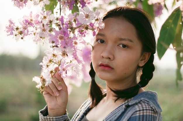 Portret Aziatisch meisje met mooie paarse bloem.