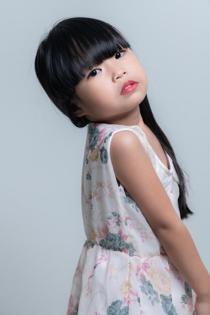 Portret aziatisch schattig klein meisje poseren voor het nemen van een foto in de studio op witte achtergrond