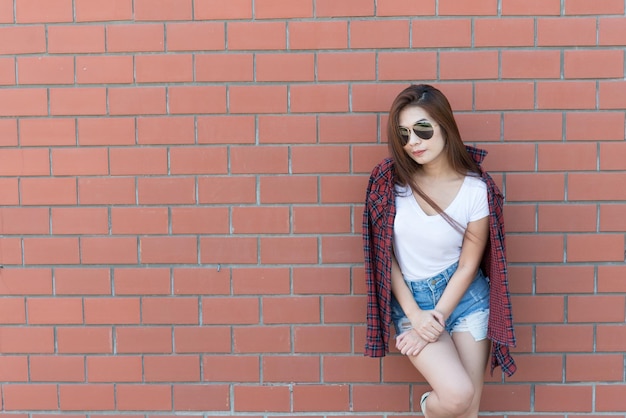 Portret Aziatische hipster meisje op bakstenen muur achtergrondHippie jurk stijlThailand moderne vrouw levensstijlSchoonheid mode portret buiten