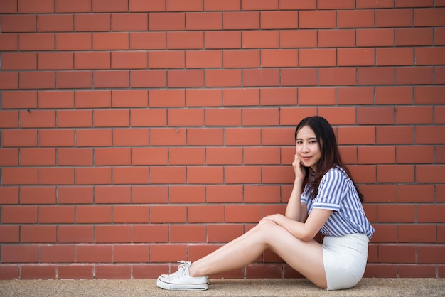 Portret Aziatische hipster meisje op bakstenen muur achtergrondHippie jurk stijlThailand moderne vrouw levensstijlSchoonheid mode portret buiten