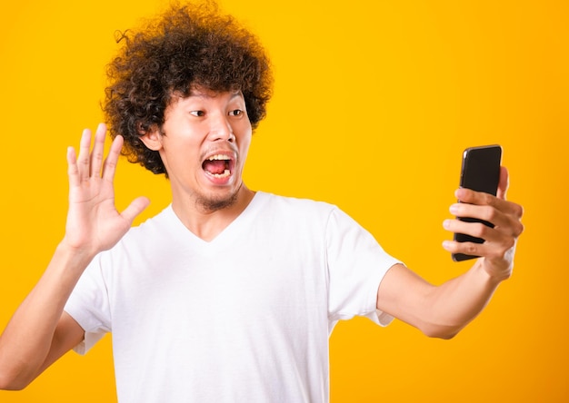 Portret Aziatische knappe man krullend haar selfie te nemen met mobiele telefoon