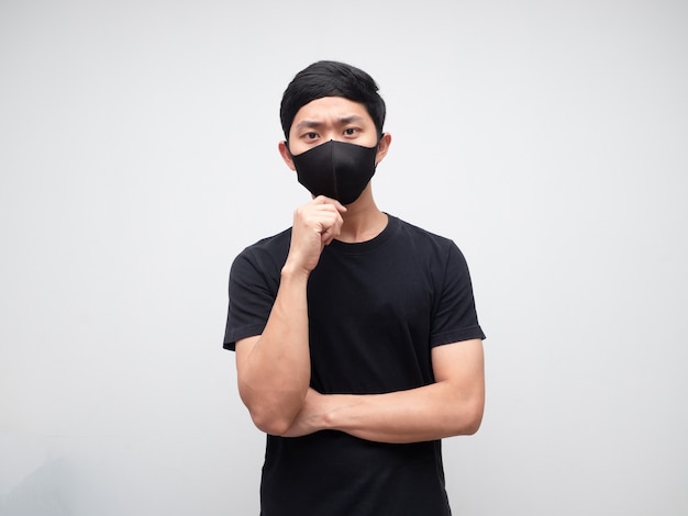 Portret aziatische man met een beschermend masker, ernstig gezicht en iets op een witte muurachtergrond