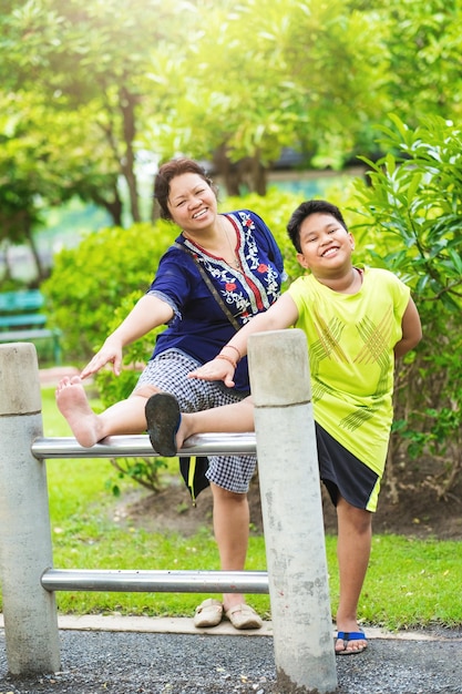 Portret aziatische moeder en zoon oefenen in de tuinsportieve vrouw en kind stretchoefening in de p