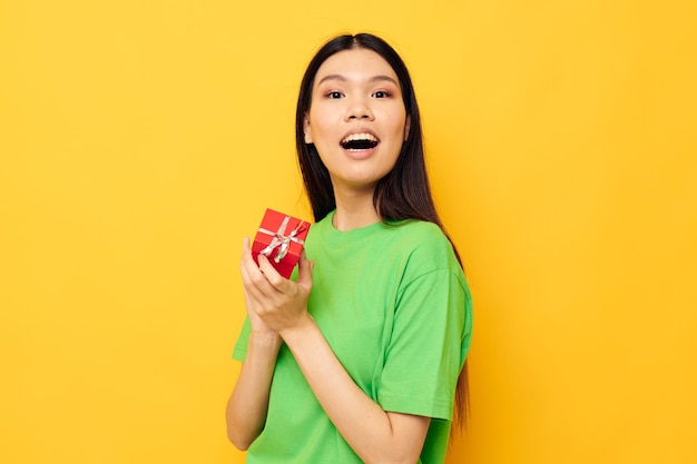 Portret Aziatische mooie jonge vrouw in groene t-shirts met een klein studiomodel van de geschenkdoos ongewijzigd