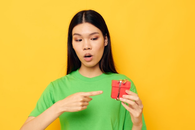 Portret Aziatische mooie jonge vrouw in groene t-shirts met een klein studiomodel van de geschenkdoos ongewijzigd