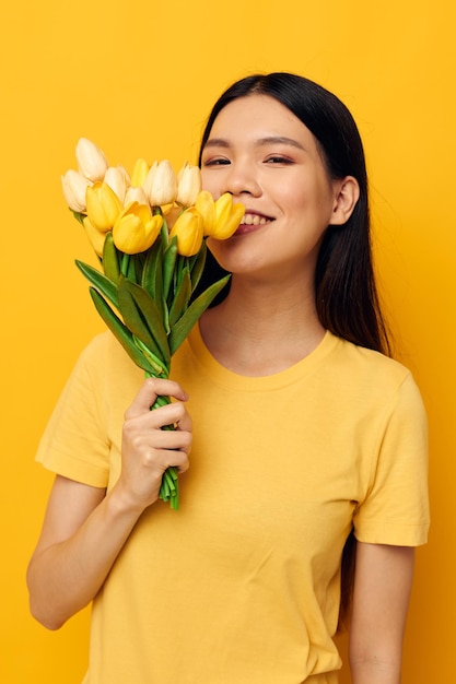 Portret Aziatische mooie jonge vrouw met een boeket van gele bloemen romantiek geïsoleerde achtergrond un...