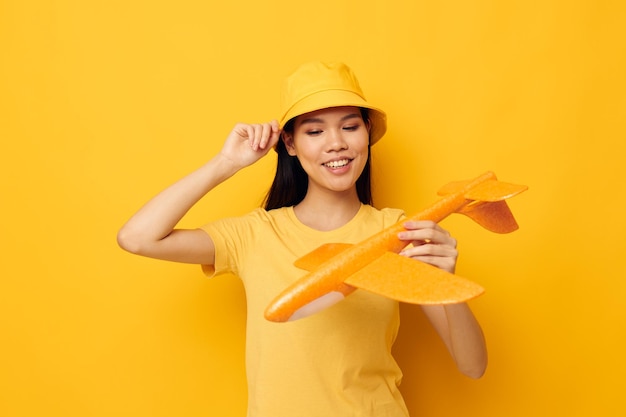 Portret Aziatische mooie jonge vrouw met een geel vliegtuig in zijn handen een stuk speelgoed Monochrome shot
