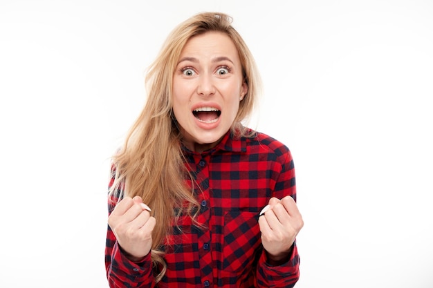 Portret boze blonde jonge vrouw schreeuwen geïsoleerd op witte studio achtergrond met negatieve emoties