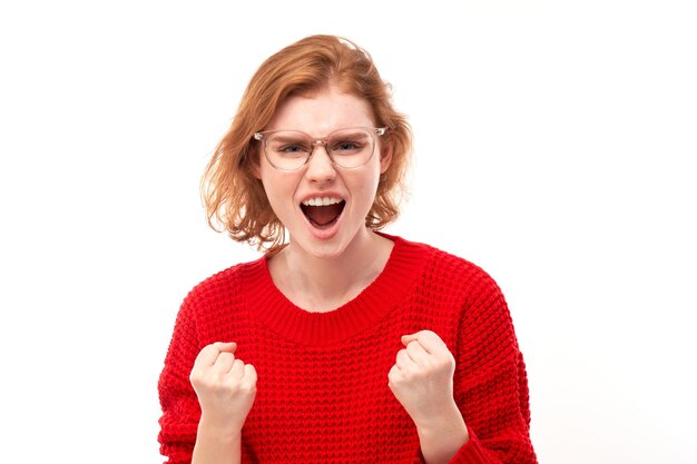 Portret boze roodharige jonge vrouw schreeuwen geïsoleerd op witte studio achtergrond met negatieve emoties xA