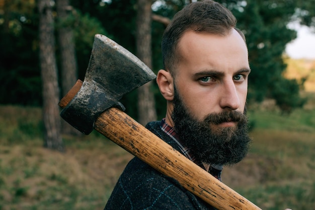 Portret brutale bebaarde en besnorde houthakker hipster zigeuner man in het bos met axx9
