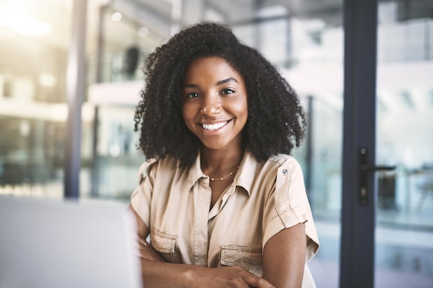 Portret bureau en zwarte vrouw met zelfvertrouwen glimlach en laptop voor business development manager in het kantoor over ons gelukkig adviseur of consultant met kans trots of ambitie bij online agentschap