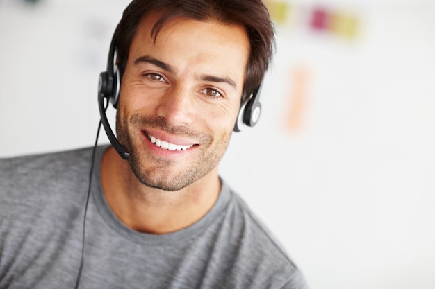 Portret callcenter en gelukkige man in opstarten voor virtuele communicatie online ondersteuning of e-learning consultant Gezicht van agent webadviseur of persoon met hulp bij e-learningservices en cursusinformatie