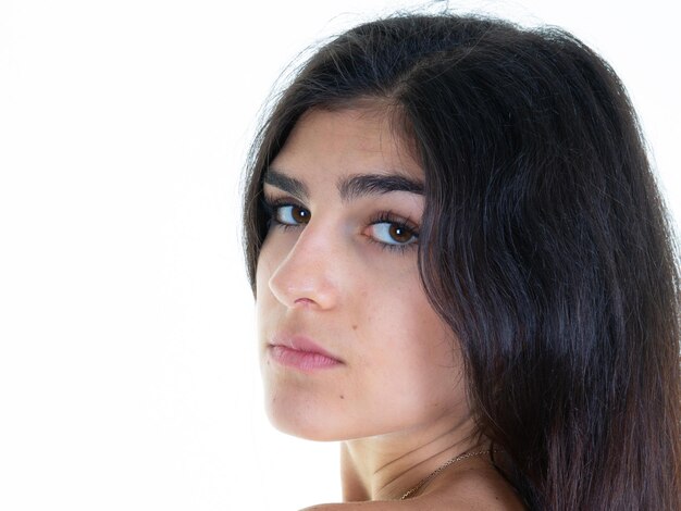 Portret close-up jonge vrouw brunette lang haar tegen een witte achtergrond