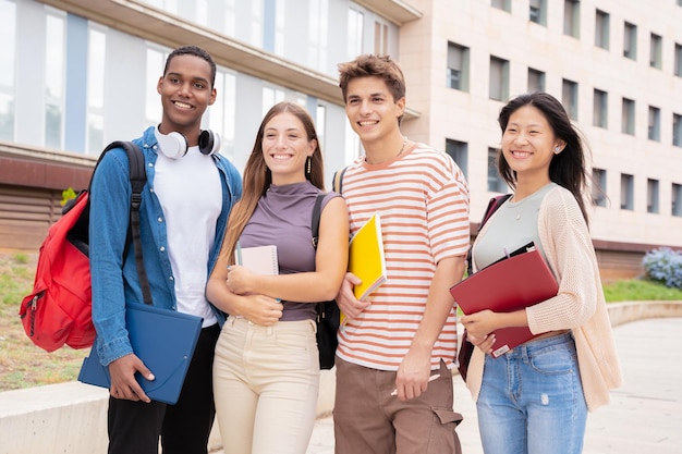 Portret close-up multiraciale groep studenten die buiten naar de camera glimlachen