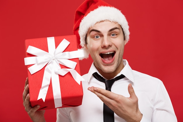 portret close-up Santa christmas zaken man op rode achtergrond rood geschenk te houden.