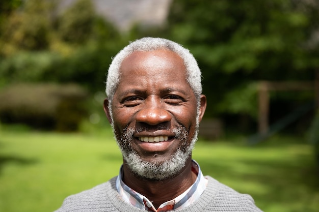 Portret close-up van glimlachende senior Afro-Amerikaanse man in een tuin die naar de camera kijkt. Familie genieten van tijd thuis, lifestyle concept