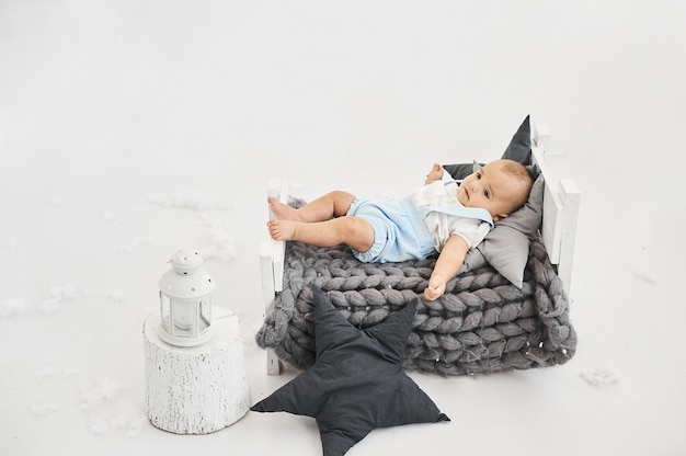 A portret of a cute baby in a little bed on a white background