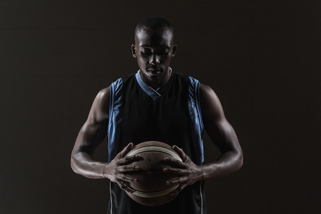 Portret dat van basketbalspeler een bal houdt