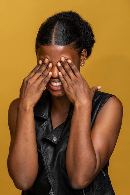 Foto portret dat van gelukkige afrikaanse vrouw haar ogen behandelt